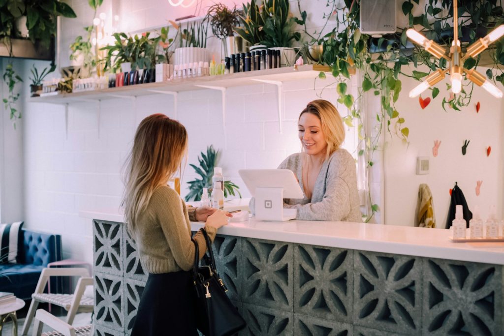 Customer at reception counter with business owner