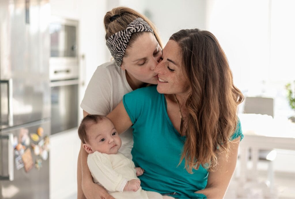 a young female couple with their baby, gay parents, gay marriage and adoption concept