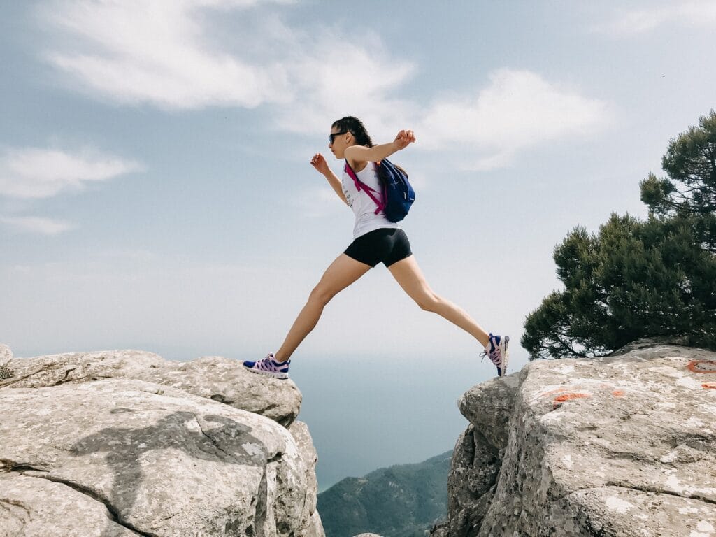 Girl jumping over a cliff